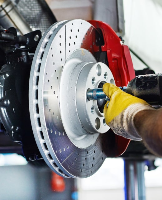 Car mechanic in a garage repairs a bracke